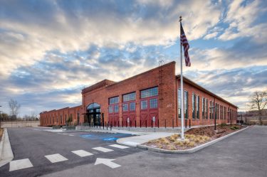 exterior of brick building with flag pole out front