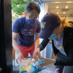 Student volunteers look at medical supplies inside a van.