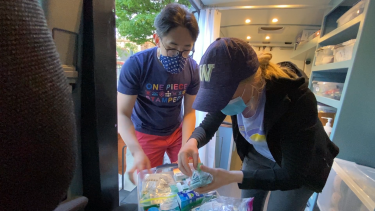 Student volunteers examine medical supplies in a van.