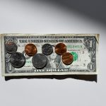 dollar bill with a few coins on top