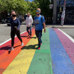 Four people walking across a rainbow painted crosswalk in Capitol Hill's Pike/Pine corridor.
