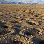 rings of rocks with mountains in background
