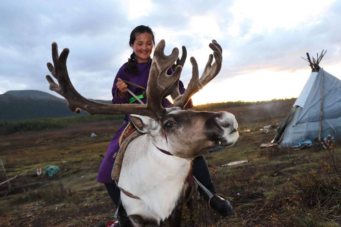 young woman on the back of a reindeer