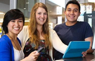 Three students viewing a tablet