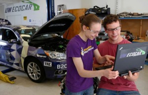 One woman and man looking at a laptop in an automotive lab