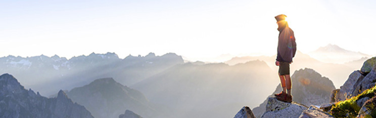 Hiker standing atop mountains