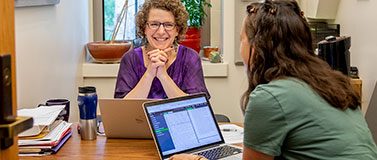 Emily M. Bender meets with a student in her office. Since she first offered her Ethics and Natural Language Processing course, ethics topics have been added to courses across the department's computational linguistics curriculum.