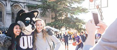 Students pose for a picture with Harry Husky on Red Square