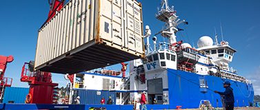 The team loads the research vessel Sikuliaq on Oct. 26 in Newport, Oregon. The shipping container in the foreground, labeled Thomson / APL-UW, contains the instruments that will be used during the expedition. John Guillote