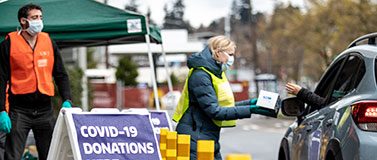 Volunteers staff a drive-up donations site on campus