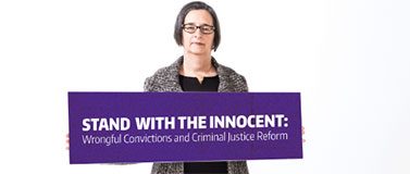 UW professor Jacqueline McMurtrie holds sign that reads 'Stand With the Innocent: Wrongful Convictions and Criminal Justice Reform'