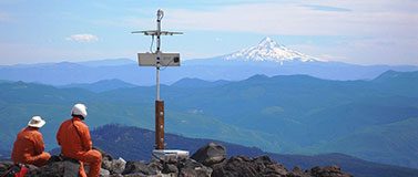 Karl Hagel and Pat McChesney, field engineers with the Pacific Northwest Seismic Network team at the University of Washington, install earthquake monitoring equipment on the slopes of Mount St. Helens, with Mount Hood in the distance.Marc Biundo/University of Washington