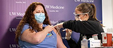 Amy Fry, a nurse in the COVID-19 ICU at Harborview Medical Center, gets the first vaccination from Allison Miller at UW Medical Center on Dec. 15.Mark Stone/University of Washington