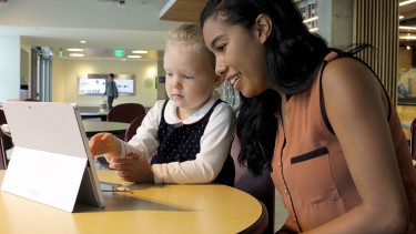 Victoria Chambers teaches a young girl how to use the motion-sensing software she helped develop last summer at MultiModal Health.