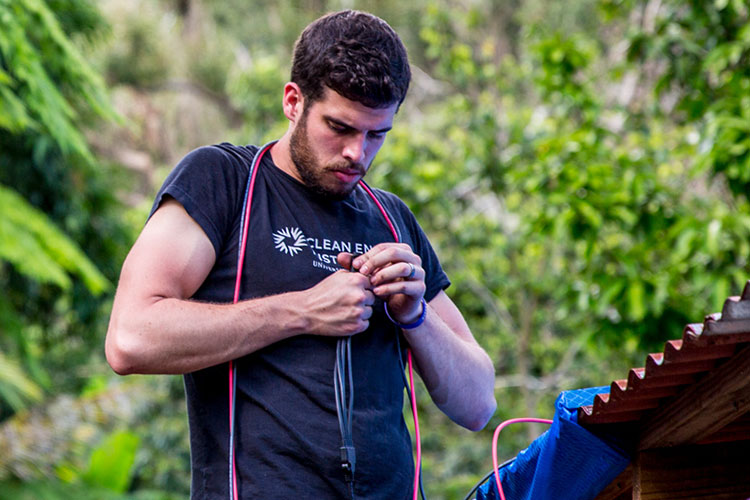 A worker installs a solar panel on a home in Puerto Rico.