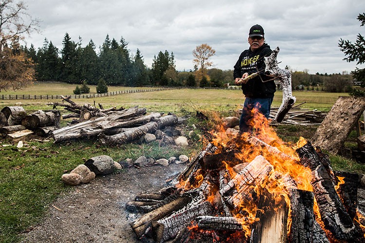 A man builds a fire in a rural area.