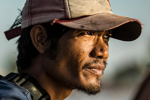 Cambodian fisherman gazing into the sun
