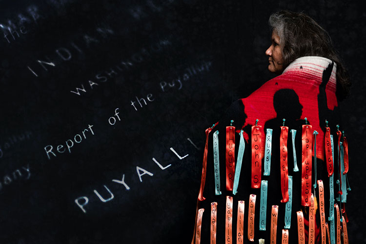Tami Hohn wears a handcrafted blanket entwined with ribbons bearing the names of her ancestors, her family members and other first-language speakers of Southern Lushootseed.