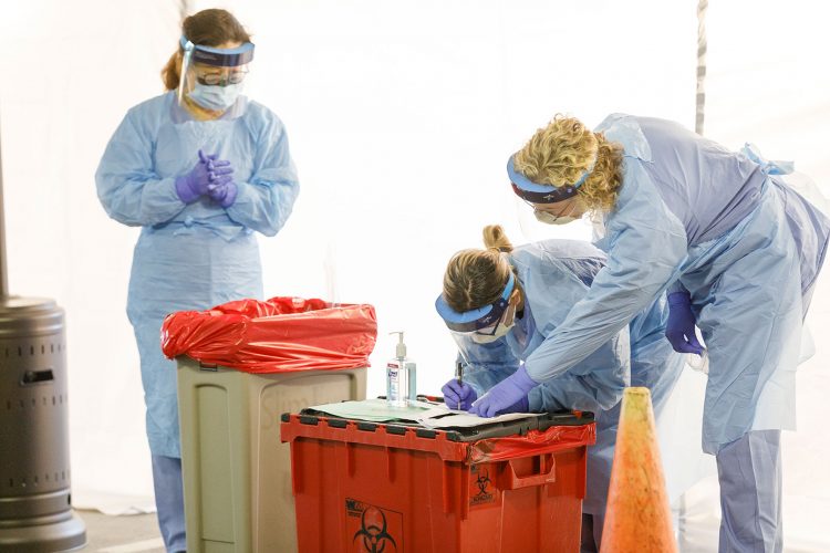 Health-care workers process samples taken at a UW Medicine drive-thru novel coronavirus testing site.