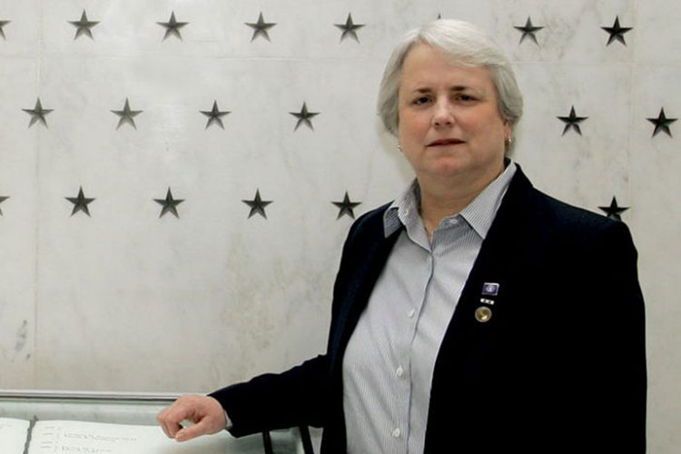 UW alum Helen Noyes poses for a picture at a CIA memorial wall