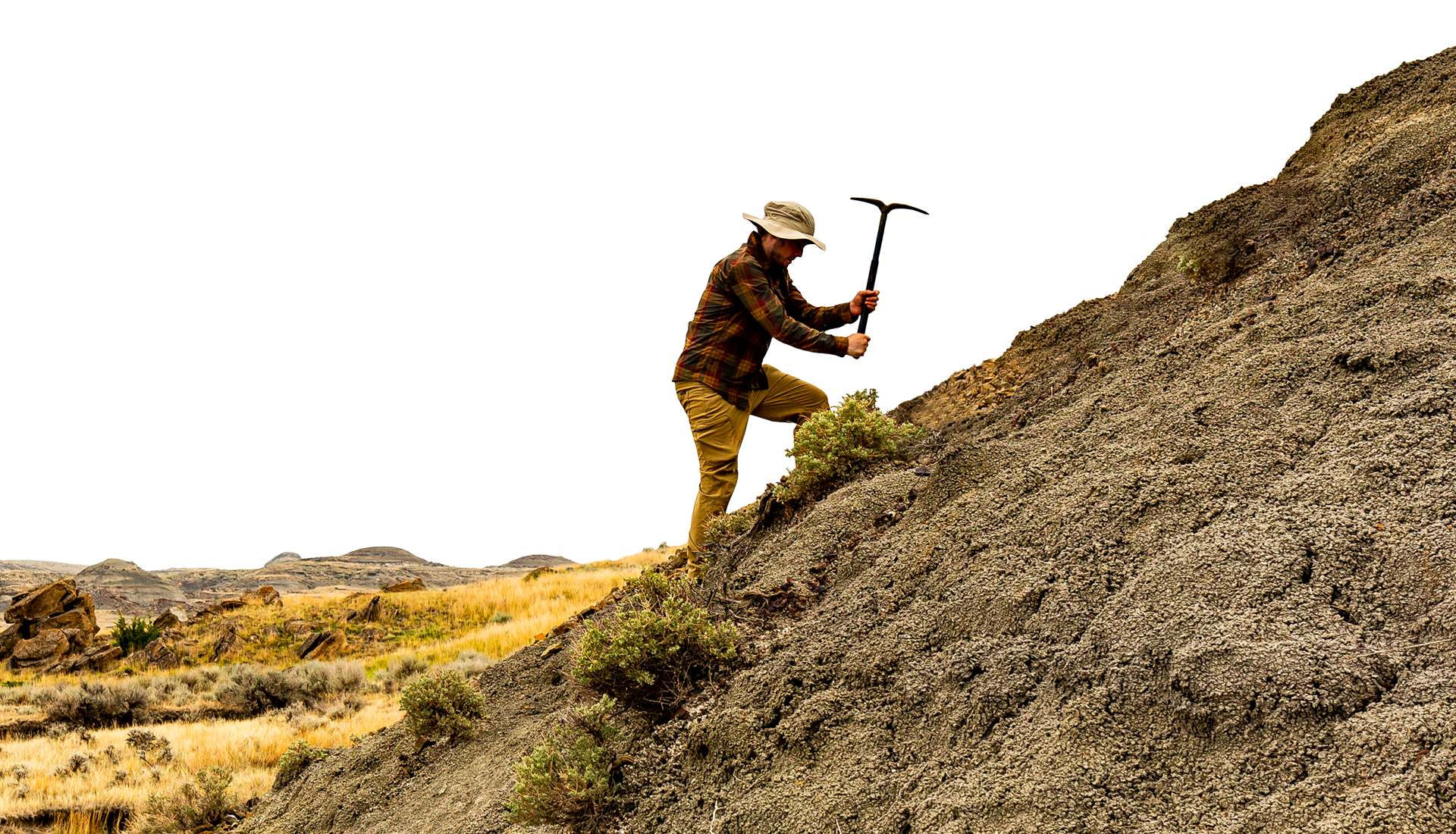 Person using a pickaxe on hillside