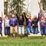 Students jumping in front of the Sylvan Columns