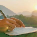 Hand writing against a pastoral background