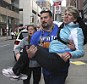 Hero: Former NFL lineman Joe Andruzzi was pictured carrying an injured woman away from the bomb blasts on Monday