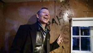 Paul at Denmark St, posing next to the drawing John did of him.