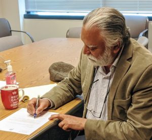County Executive Satpal Sidhu signs Whatcom County's application to move to Phase 2 of Safe Start Washington.