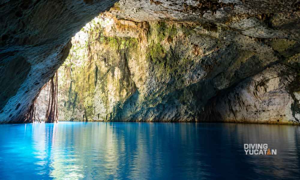 Vista del cenote Nah-Yah con su abertura, paredes de roca y espejo de agua.