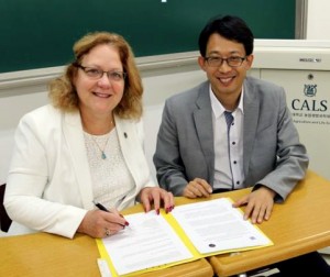 Rasco and Kang signing paperwork together