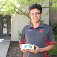 Interim director, Dr. Ganjyal, holding a can of Cougar Gold Cheese