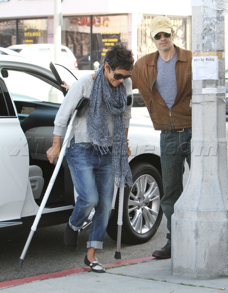 denim crutches scarf sunglasses jacket hat injury smile coffee 