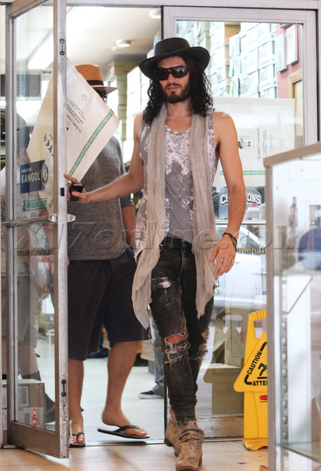 Russell Brand  hat scarf jeans sunglasses boots 