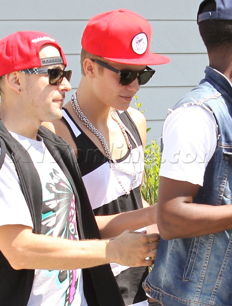 hat hiding Justin Bieber striped tank outback steakhouse posse sneakers sunglasses 