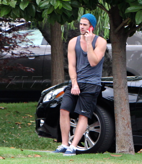 Miley Cyrus singer Liam Hemsworth beanie tank top shorts hug 